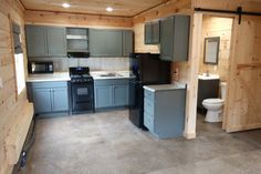 a kitchen with gray cabinets and black appliances