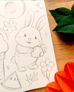 a drawing of a bunny holding an apple next to some paper flowers and a potted plant