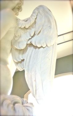 an angel statue sitting on top of a white table