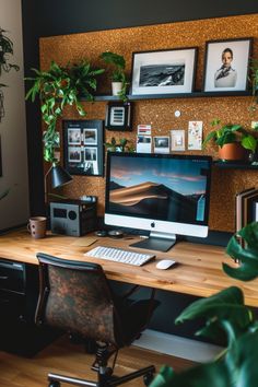 a desk with a computer on top of it next to a potted plant and pictures