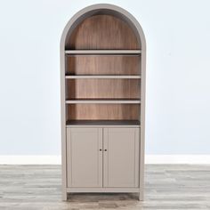 an arched bookcase with two doors and shelves