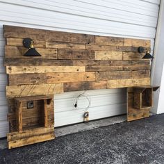 a wooden bench made out of pallets with two lights on each side and one light attached to the wall