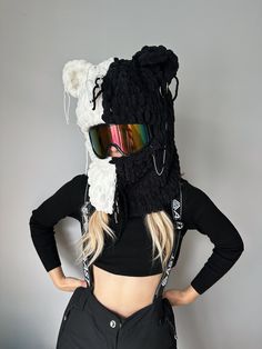 a woman wearing ski goggles and a knitted bear mask on top of her head