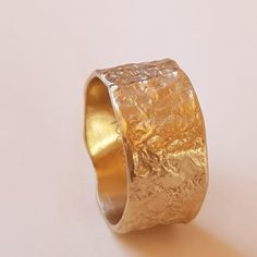 Organic form meets expert craftsmanship with this stunning solid 18K gold women’s wedding band. A subtle yet sensational statement, this piece has an apparent weight and impressive width with naturally undulating sides and a rough-textured surface.Each ring is handcrafted and one of kind just like the singular union they represent.◈ DETAILSWeight: 6gWidth: 12-13mm / 0.47''- 0.51''Thickness: 1.1-1.5mm / 0.39''- 0.06''◈ MATERIAL18K Solid Gold◈ ALSO AVAILABLE IN 14K Yellow, Rose, or White Gold◈ ENG Gold Hammered Thick Band Ring, Gold Hammered Wide Band Ring, Modern Wide Band Ring With Hammered Detail, 14k Gold Hammered Wide Band Ring, Elegant Hammered Thick Band Rings, Hand Forged Wide Band Ring For Gift, Hand Forged Wide Band Ring As Gift, Heirloom Hammered Yellow Gold Rings, Hand Forged Thick Band Wide Ring