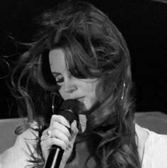 a woman with long hair holding a microphone