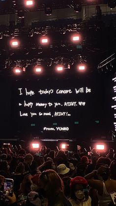 a large group of people standing in front of a screen with words written on it