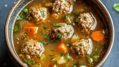 a bowl filled with meatball soup on top of a table