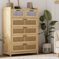 a wooden cabinet sitting next to a white couch in a room with plants and potted plants