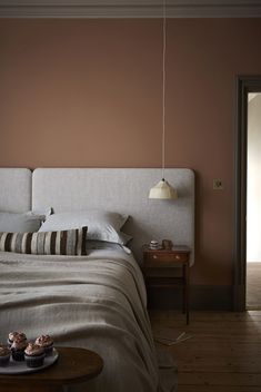 a bed sitting in a bedroom next to a table with food on top of it