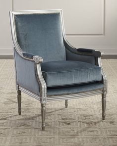 a blue chair sitting on top of a carpeted floor next to a white wall