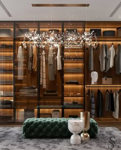 a walk - in closet with an ottoman and chandelier