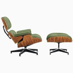 an eames lounge chair and ottoman with green upholstered fabric on the back