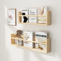 two wooden shelves holding books and magazines on the wall next to a vase with succulents