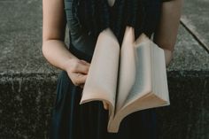 a woman holding an open book in her hands