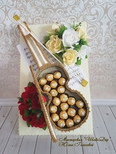 there is a cake with chocolates in the shape of a heart and flowers on it