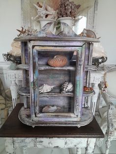 an old cabinet with seashells and shells in it