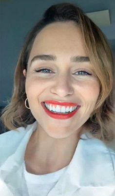 a smiling woman with red lipstick on her lips