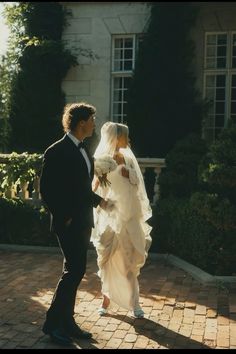 the bride and groom are walking together outside