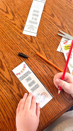 a person is doing something on a table with some papers and pencils next to them