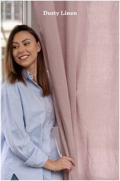 a woman standing next to a pink curtain with the words dusty linen written on it