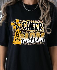 This Cheer Mom T-shirt is the perfect gift and show of support for any cheer mom. With a design featuring a cheer megaphone, bow, and gold accents, this shirt is a must-have for any proud cheer mom. Whether at a cheer competition, football game, or just running errands, this comfortable and stylish t-shirt is sure to make a statement. Ideal for Mother's Day, birthdays, or just to show appreciation for all that cheer moms do. ⭐⭐These unisex shirts are designed to be loose-fitting. For a tighter f Cheer Competition, Cheer Megaphone, Football Cheer, Sports Mom Shirts, Mom Support