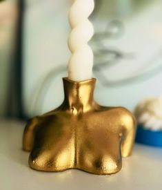 a gold candle holder sitting on top of a table