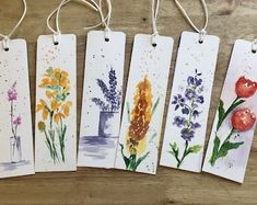 four tags with flowers painted on them