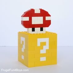 a lego mario mushroom sitting on top of a yellow box with question mark in it