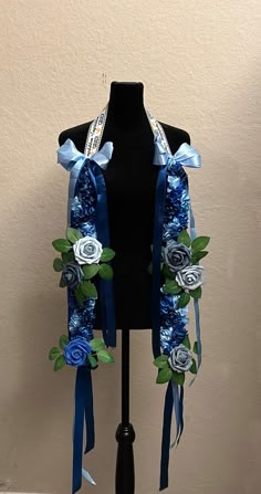 a black mannequin with blue ribbon and flowers on it