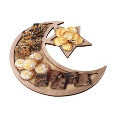 a wooden plate with cookies and pastries arranged on the moon shaped platter for hanukkah