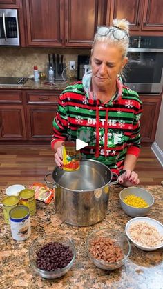 a woman in a red and green christmas sweater is making food on the kitchen counter