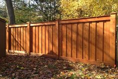 a wooden fence surrounded by leaves and trees