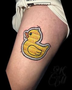 a yellow rubber ducky tattoo on the right thigh