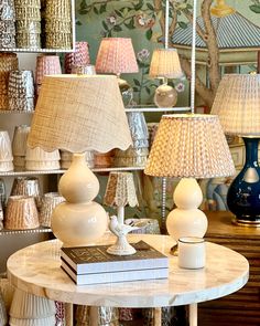 a room filled with lamps and books on top of a table