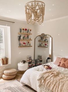 a bed room with a neatly made bed and a chandelier hanging from the ceiling