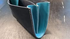 a black and blue wallet sitting on top of a wooden table