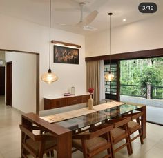 the dining room table is surrounded by wooden chairs and an open sliding glass door that leads to a patio