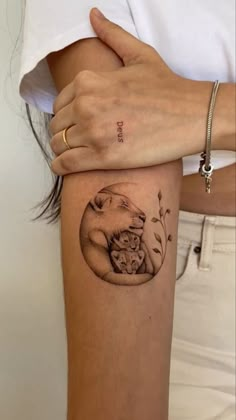 a woman's arm with a tattoo on it that has an image of a cat and flowers