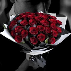 a man holding a bouquet of red roses