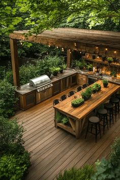 Outdoor kitchen with a wooden pergola, bar seating, grill, and lush greenery. Kitchen Garden Layout, Raised Bed Kitchen Garden, Kitchen Garden Ideas, Concrete Outdoor Kitchen, Covered Outdoor Kitchens, Rustic Outdoor Kitchens, Dream Setup, Outdoor Cooking Spaces, Outdoor Gathering Space