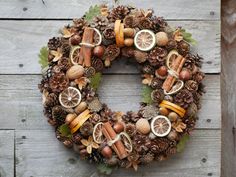 a wreath made out of pine cones, oranges and nuts