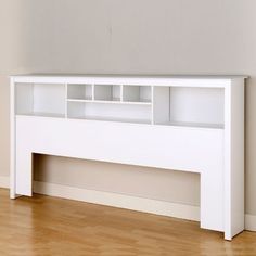 a white book shelf sitting on top of a hard wood floor