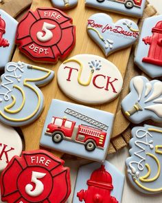 decorated cookies with firetruck, fire hydrant and number five on wooden board