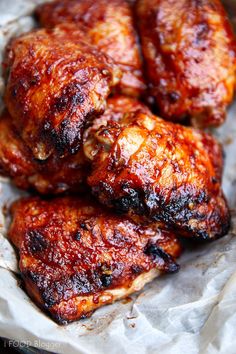 chicken wings covered in bbq sauce sitting on wax paper