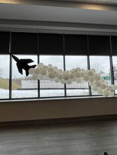 an airplane made out of balloons in front of a window