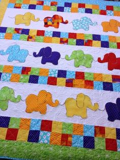 an elephant themed quilt is displayed on a table topper in the shape of a baby's bed