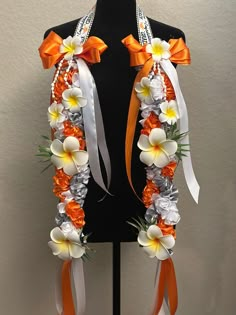 an orange and white flower lei on a mannequin