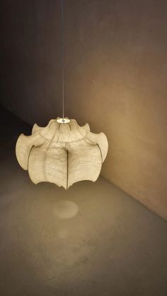 a light fixture hanging from the ceiling in a room with concrete walls and flooring