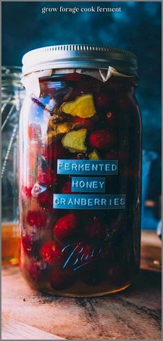 a jar filled with fruit sitting on top of a wooden table