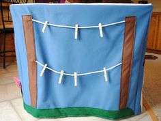 a blue and brown box with clothes pins attached to the front, sitting on top of a tile floor